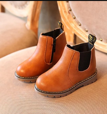 Boys and girls low-cut brown boots on a chair.