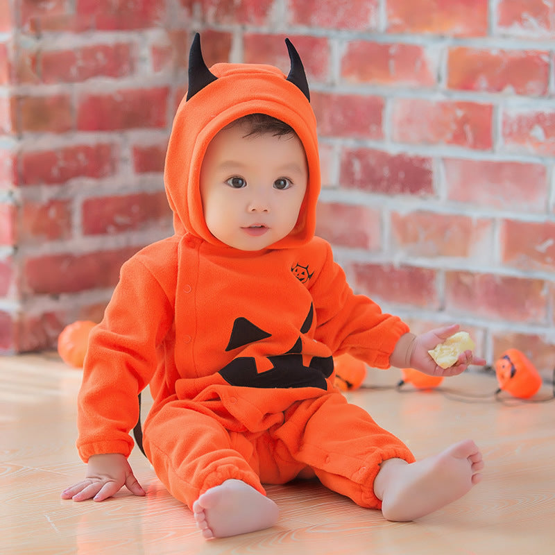 Baby wearing Halloween pumpkin hooded jumpsuit with black jack-o'-lantern design.