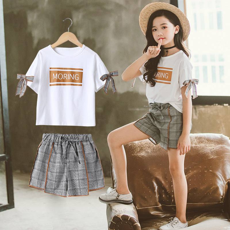 Big kids short sleeve casual morning set with a pullover white top and plaid shorts.