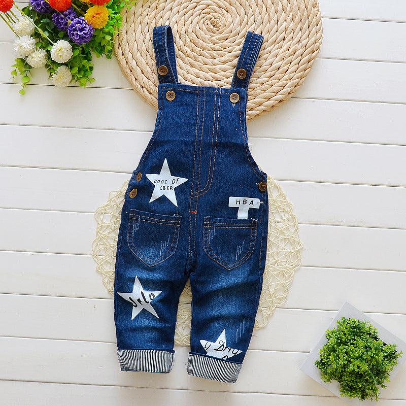 new style children's overalls jeans jumper in blue with star patches on a woven mat background