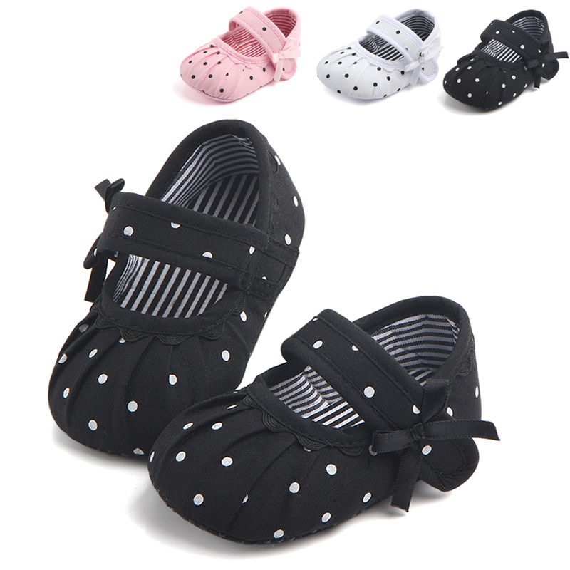 Baby girls polka dot anti-slip shoes with strap in black, pink, and white options.