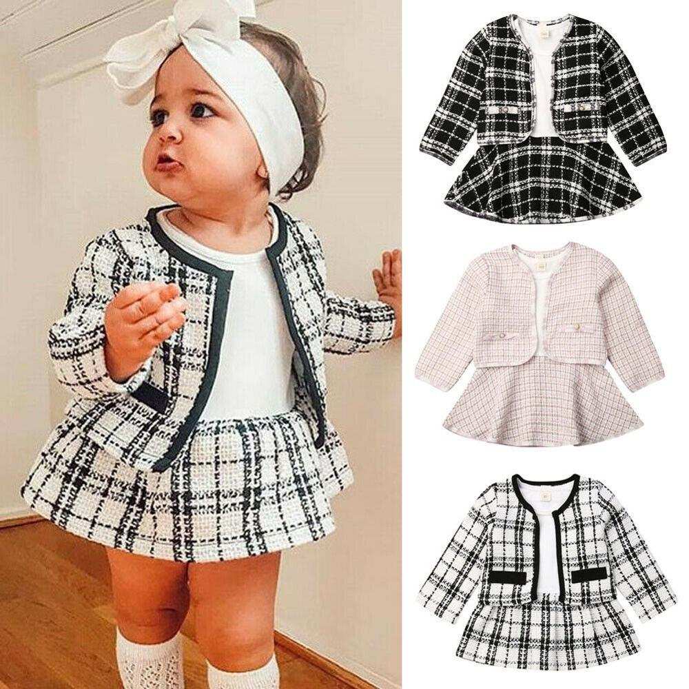 Plaid long-sleeved dress two-piece baby girl suit in black, white, and pink.