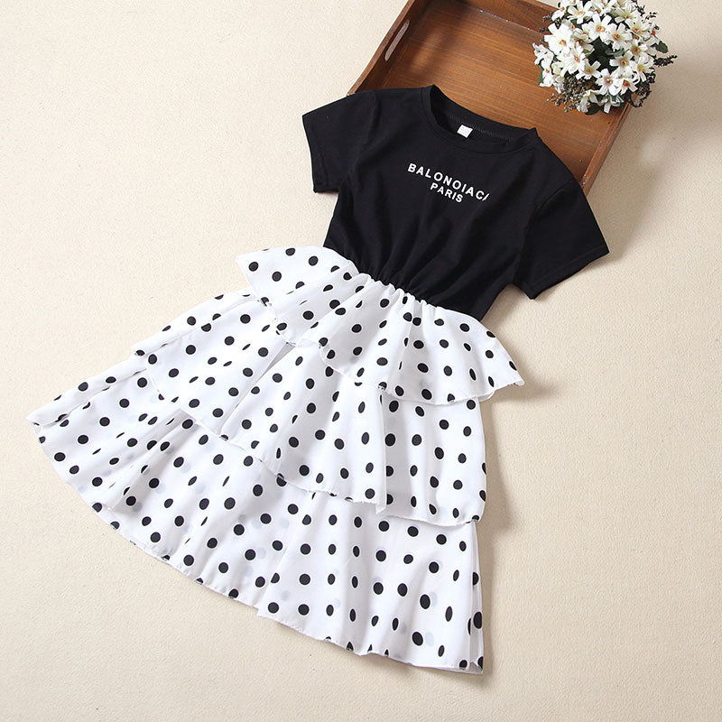 Big kids short sleeve casual dress with black top and white polka dot skirt.