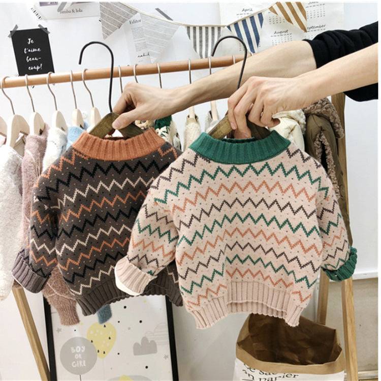 Children's wool zig zag sweater with long sleeves in brown and apricot, shown on hangers.