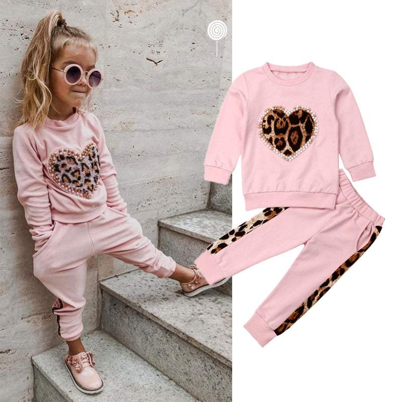 Girls' pink print sweatshirt two-piece set with heart design and leopard details.