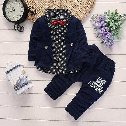Toddler boys' casual suit set with navy jacket, polka dot shirt, and pants on a wooden background.