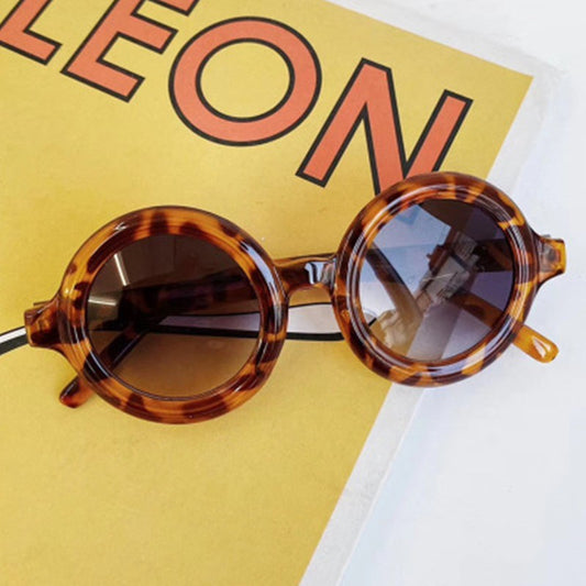 Kids UV protection sunglasses with leopard print frame on a colorful background.