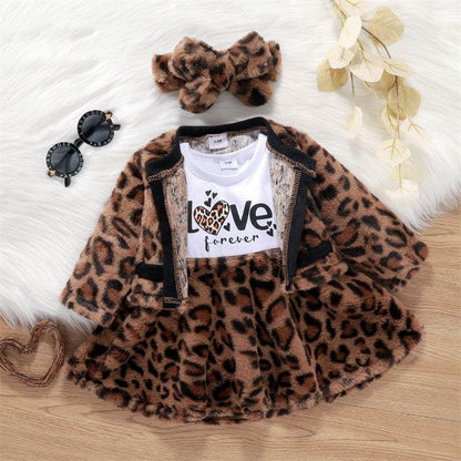 Baby girl leopard print dress with jacket, head knot, and "love forever" top on wooden background.